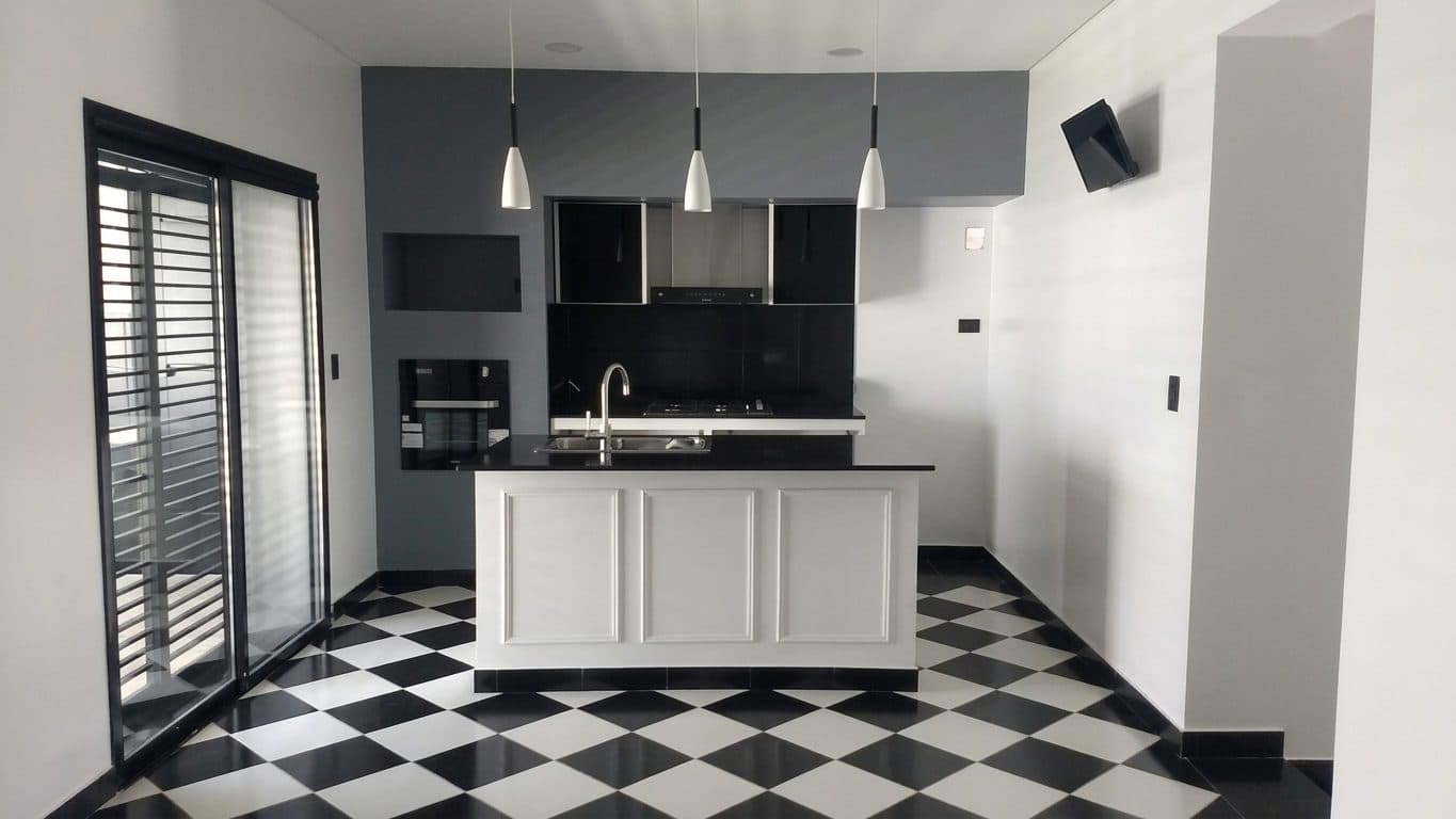 Cocina con isla y piso damero de la vivienda en Barcala